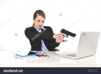 ive-businesswoman-pointing-gun-to-computer-laptop-sitting-at-office-desk-desperate-and-236887447.jpg