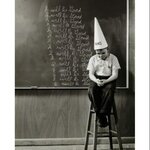 boy-wearing-a-dunce-cap-sitting-in-front-of-a-blackboard-poster-print-18-x-24_902354.jpg
