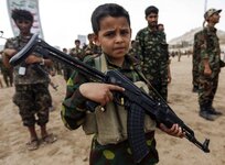 A Yemeni boy poses with a Kalashnikov assault rifle during a gathering of newly-recruited Huth...jpg
